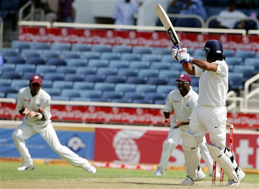 India's batsman Mahendra Dhoni, right, watches as he is caught by West Indies' Dwayne Bravo, left, off the bowling of Corey Collymore during the fourth cricket Test match at Kingston. Ind-WI 4th Test Day 1
