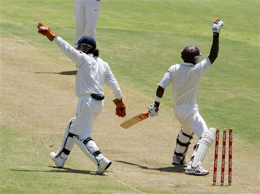 India's wicket keeper M S Dhoni, left, reacts after he stumped West Indies batsman Marlon Samuels, right, off the bowling of Anil Kumble on the second day of the fourth cricket Test at Kingston. Ind-WI 4th Test Day 2