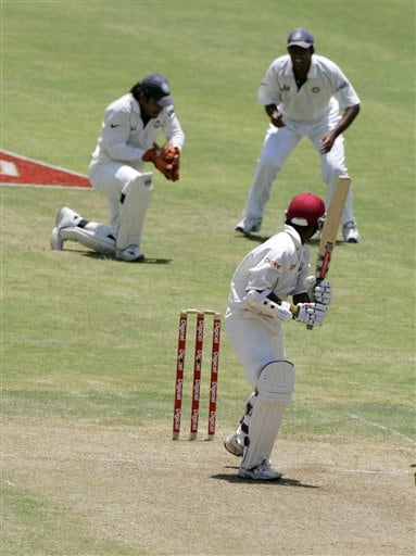 West Indies batsman Shivnarine Chanderpaul, right, looks back as he is caught by India's wickket keeper M S Dhoni, left, off the bowling of Munaf Patel on the second day of the fourth cricket Test at Kingston. Ind-WI 4th Test Day 2