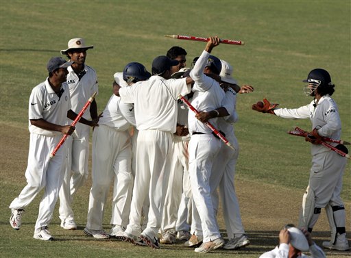 India's wicket keeper Mahendra Dhoni, right, passes a match ball to a teammate as they celebrate their victory over the West Indies on the third day of the fourth and final cricket test match at Sabina Park in Kingston, Jamaica Sunday, July 2, 2006. India won by 49 runs, and won the series 1-0. Ind-WI 4th Test Day 3