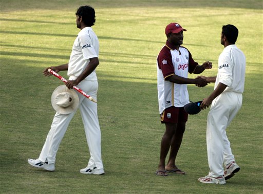West Indies captain Brian Lara, center, shakes hands with Indiia's captain Rahul Dravid, right, following India's victory on the third day of the fourth and final cricket test match at Sabina Park in Kingston, Jamaica Sunday, July 2, 2006. India won by 49 runs, and won the series 1-0. At left is India's bowler Munaf Patel. Ind-WI 4th Test Day 3