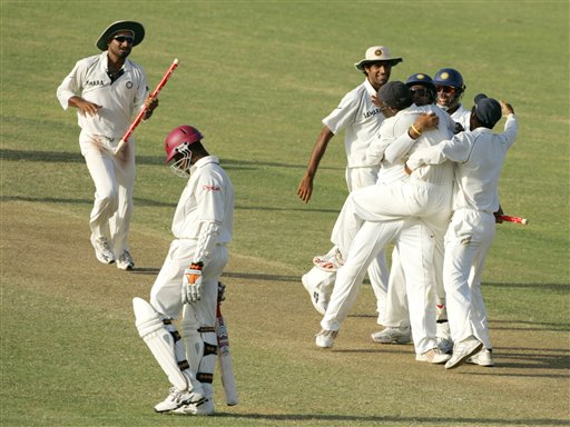 West Indies batsman Corey Collymore, front left, walks off the field as India's Harbhajan Singh, left rear, and other players celebrate their victory on the third day of the fourth and final cricket test match at Sabina Park in Kingston, Jamaica Sunday, July 2, 2006. India won the match by 49 runs and the series 1-0. Ind-WI 4th Test Day 3
