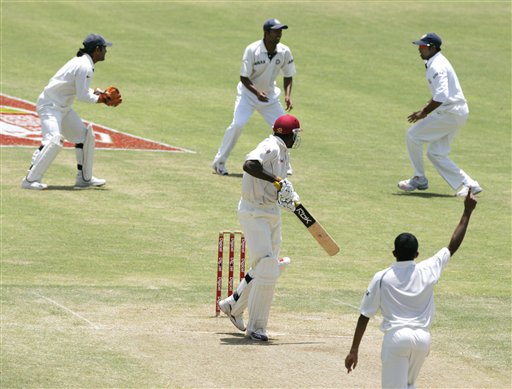 West Indies batsman Chris Gayle, center in red helmet, loooks behind after being caught out for a duck off the bowling of India's Shanthakumaran Sreesanth, foreground, on the third day of the fourth and final cricket test match at Sabina Park in Kingston, Jamaica Sunday, July 2, 2006. Ind-WI 4th Test Day 3