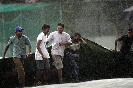 Ground staff of the Colombo Colts cricket ground rush with the rain covers after rain stopped play for a while, during a practice match against Sri Lanka A, in Colombo. India practices in Sri Lanka