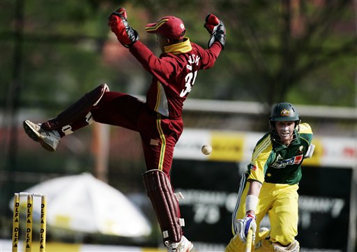 Australian batsman Micahel Hussey, right, runs to his crease as the West Indies' wicketkeeper Carlton Baugh struggles to handle a high through in their tri-series match in Kuala Lumpur on Monday. DLF Cup Round 2 WI-Aus