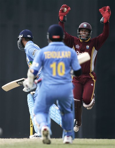 West Indies' wicketkeeper Carlton Baugh, right, celebrates catching out Indian batsman Harbhajan Singh, left, for 37 runs as Sachin Tendulkar looks on in their tri-series match in Kuala Lumpur on Wednesday. DLF Cup Rd 2 Ind-WI