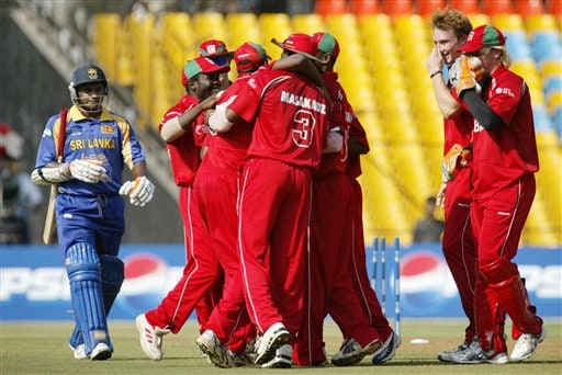 Sri Lankan cricketer Sanath Jayasuriya, left, walks towards the pavilion after being dismissed, as cricketers from Zimbabwe celebrate during the ICC Champions Trophy's qualifying match in Ahmedabad on Tuesday. ICC CT Sri Lanka-Zimbabwe