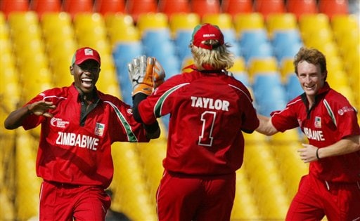 Elton Chigumbura, left, celebrates dismissal of Sanath Jayasuriya of Sri Lanka, unseen, with teammates Brendon Taylor, center, and Anthony Ireland of Zimbabwe during the ICC Champions Trophy's qualifying match in Ahmedabad on Tuesday. ICC CT Sri Lanka-Zimbabwe
