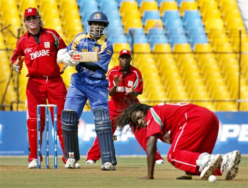 Sri Lankan cricketer Upul Tharanga, second left, looks on as Zimbabwe's Tawanda Mupariwa, on ground, tries to stop a ball during the ICC Champions Trophy's qualifying match in Ahmedabad on Tuesday. ICC CT Sri Lanka-Zimbabwe