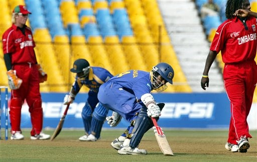 Sri Lankan cricketers Upul Tharanga, second right, and Sanath Jayasuriya, second left, run between the wickets as Zimbabwe's Tawanda Mupariwa, right, and wicket keeper Brendon Taylor, left, look on during the ICC Champions Trophy's qualifying match in Ahmedabad on Tuesday. ICC CT Sri Lanka-Zimbabwe