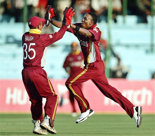 West Indies cricketer Dwayne Bravo, right, and wicket keeper Carlton Baugh celebrate the dismissal of Bangladesh's Mashrafe Mortaza, unseen, during the one-day international cricket match for the ICC Champions Trophy in Jaipur on Wednesday. ICC CT WI-Bangladesh
