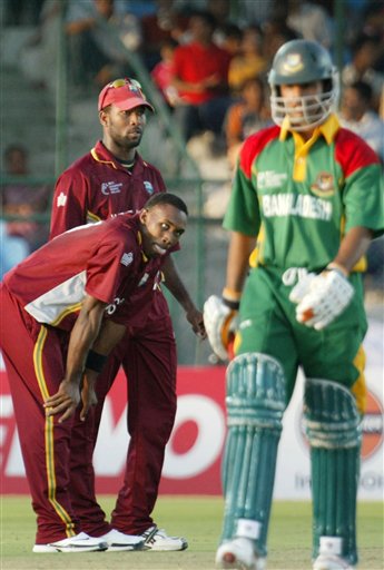 West Indies cricketer Dwayne Bravo, bending, gestures, as teammate Corey Collymore looks on after dismissing Bangladesh's Abdur Razzak, right, during the ICC Champions Trophy qualifying match in Jaipur on Wednesday. ICC CT WI-Bangladesh