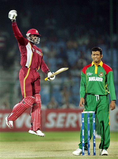West Indies cricketer Chris Gayle celebrates his century, as Bangladesh's Abdul Razzak looks on during the one-day international cricket match for the ICC Champions Trophy in Jaipur on Wednesday. ICC CT WI-Bangladesh