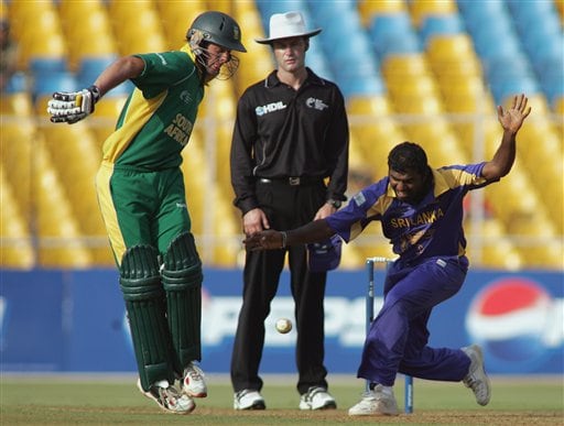 Sri Lankan cricketer Muttiah Muralitharan, right, tries to field a ball as South African batsman Abraham Devilliers tries to get out of his way in Ahmadabad on Tuesday. ICC SA-SL