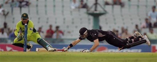 New Zealand's Stephen Fleming, right, dives successfully to complete his run as Pakistan's wicket keeper Kamran Akmal attempts for a run out during the one day international cricket match for the ICC Champions Trophy in Mohali ICC CT NZ-Pak