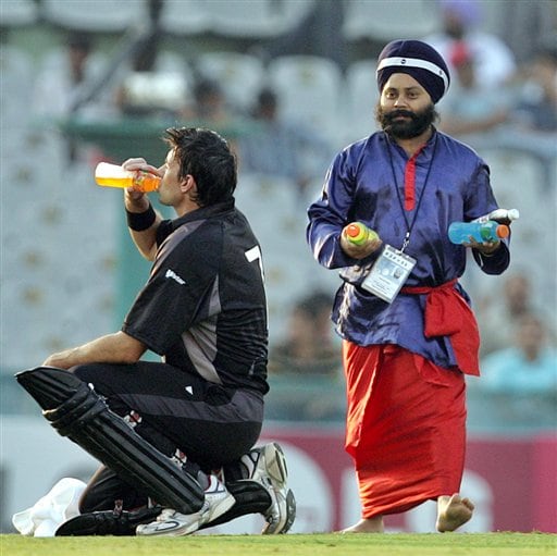 A Sikh carries refreshments as New Zealand's Stephen Fleming, left, drinks during the one day international cricket match against Pakistan for the ICC Champions Trophy in Mohali ICC CT NZ-Pak