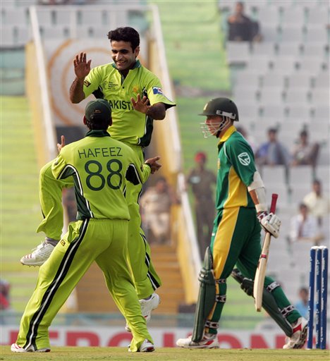 Pakistan's Iftikhar Anjum, without cap, and teammate Mohammad Hafeez celebrate a dismissal of South Africa's Boeta Dippenaar, right, during their one-day international cricket match for the ICC Champions Trophy in Mohali on Friday. ICC CT Pak-SA