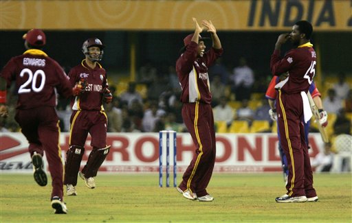 West Indies' Ramnaresh Sarwan, center, congratulates bowler Chris Gayle, right, after Gayle took the wicket of England's Paul Collingwood, unseen, during the ICC Champions Trophy cricket tournament match in Ahmedabad on Saturday. ICC CT WI-Eng
