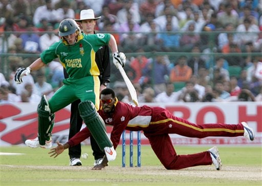 South African batsman Abraham Devilliers, left, jumps as West Indies' Chris Gayle tries to field off his own bowling in the second semi-final of the ICC Trophy cricket tournament in Jaipur ICC CT WI-SA