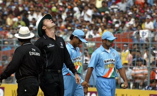 Indian captain Rahul Dravid, right, leaves the ground along with Sourav Ganguly, second right, as umpire Simon Tuffel, second left, looks to the sky during first one-day international match between India and Sri Lanka in Kolkata on Thursday, February 8, 2007. Ind-SL 1st ODI