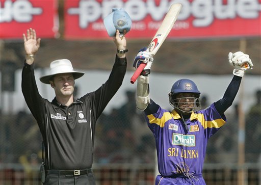 Sri Lankan cricketer Kumar Sangakkara, right, celebrates his century against India as Umpire Simon Taufel gestures for a boundary during the second one-day international in Rajkot, India, Sunday, February 11, 2007. Ind-SL 2nd ODI