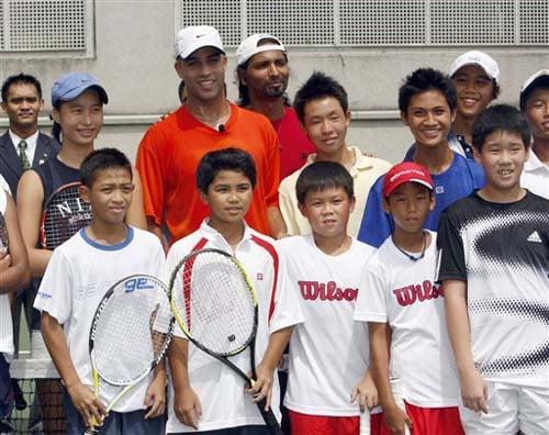 James Blake poses with children for pictures after a tennis training workshop in Kuala Lumpur on Tuesday. Blake will play against Roger Federer of Switzerland in an exhibition match later on Tuesday. Showdown of champions