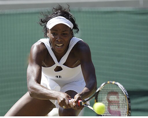 Venus Williams of the USA, returns to Thailand's Tamarine Tanasugarn during their Women's singles quarterfinal match on the Number One Court at Wimbledon. Wimbledon Day 8