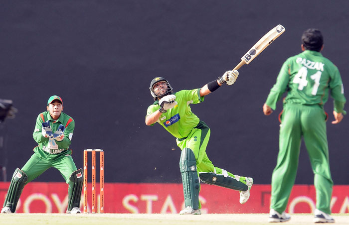 Shahid Afridi plays a shot as Mushfiqur Rahim looks on during during the fifth ODI of the Asia Cup between Pakistan and Bangladesh at the Rangiri Dambulla International Cricket stadium in Dambulla. (AFP Photo) Asia Cup: Pak vs B'desh