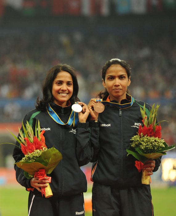 Preeja Sreedharan of India (L) and Kavita Raut of India (R) pose on the podium during the award ceremony for the women's 5,000m in the athletics competition at the 16th Asian Games in Guangzhou. (AFP Photo)
