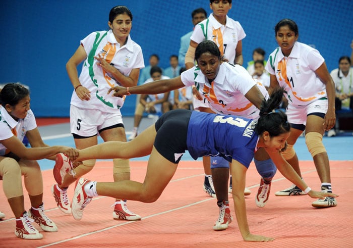 Sanahanbi Devi Kangabam (L) of India pulls down Cholada Chaiprapan of Thailand during the kabaddi women's final match at the 16th Asian Games in Guangzhou. India beat Thailand 28-14 for the gold medal. (AFP Photo)