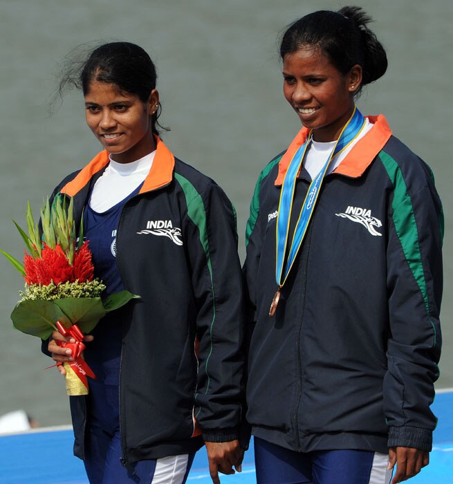 Pramila Prava Minz and Pratima Puhana of India with only one medal between them on the podium during the medals ceremony for the women's pair rowing final during the 16th Asian Games in Guangzhou. (AFP Photo)