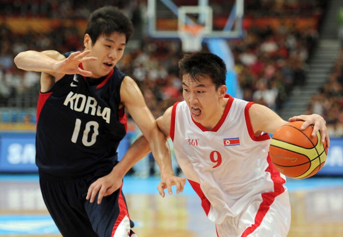 Pak Un Chol of DPR Korea (R) and Cho Sungmin of Korea (L) clash in their preliminary round group E game 20 basketball match in the 2010 Asian Games in Guangzhou. (AFP Photo)