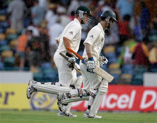 Australia's batsmen Brett Lee, left, and Beau Casson leave the pitch while rain start falling on the opening day of the third and final cricket Test match against the West Indies in Bridgetown on Thursday, June 12, 2008. West Indies restricted Australia to 226 for seven at close on a rain-shortened first day. 3rd Test, Australia vs West Indies, Day 1