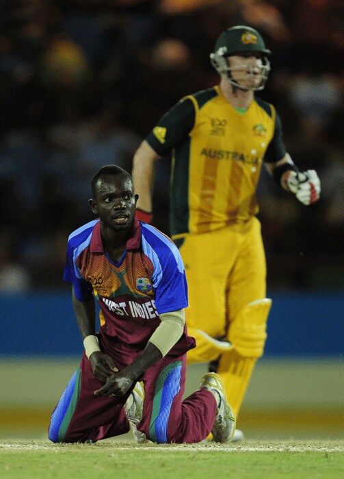 West Indies bowler Nikita Miller falls on his knees as Brad Haddin scores a run. (AFP PHOTO) WT202010