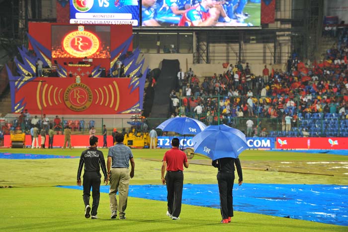 Match officials too were clueless as the weather played hide and seek here. (AFP PHOTO/Manjunath KIRAN) IPL: Another day, another washout as Bangalore, Chennai share points