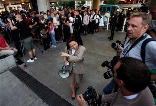Nancy Castle with Los Angeles International Airport gives instructions to photographers waiting behind barricades for the arrival of Beckham and his wife Victoria. Beckhams arrive in LA