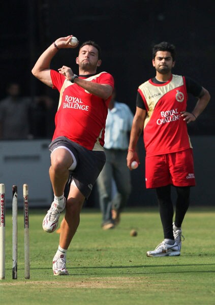 Royal Challengers Bangalore cricketer Dillon Du Preeze bowls as team mate Virat Kohli looks on, during a practice session ahead of their match against Chennai Super Kings at Chinnaswami Stadium in Bangalore on Monday. (PTI Image) Royal Challengers' net session