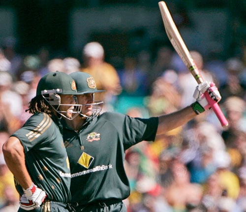 Matthew Hayden, right, raises his bat after making 50 runs against India as teammate Andrew Symonds stand alongside during the first final of their tri-nations one-day international series at the Sydney Cricket Ground on Sunday, March 2, 2008. First final - India vs Australia