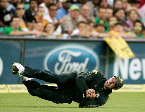 Michael Hussey rolls on the ground after catching out India's Robin Uthappa during the first final of their tri-nations one-day international series at the Sydney Cricket Ground on Sunday, March 2, 2008. Australia made 239 in their innings. First final - India vs Australia