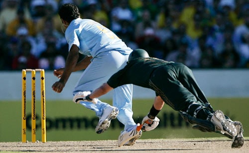 Michael Hussey, right, dives in an attempt at avoiding a run out as Irfan Pathan races to the stumps to dismiss Hussey for 45 runs during the first final of their tri-nations one-day international series at the Sydney Cricket Ground on Sunday, March 2, 2008. First final - India vs Australia