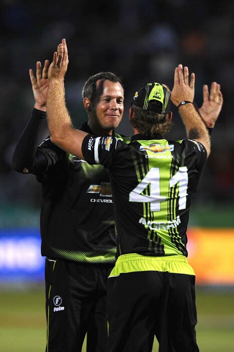Warriors bowler Justin Kreusch and fielder Colin Ingram celebrates the dismissal of Chennai Super Kings batsman Suresh Raina during the Champions League Twenty20 League match between Warriors and Chennai Super Kings at St. Georges park Stadium in Port Elizabeth. (AFP Photo) CLT20: Chennai vs Warriors