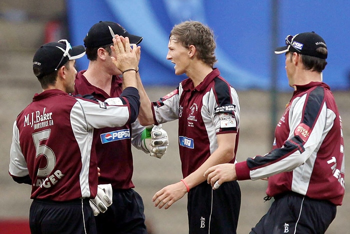 Somerset's Charl Willoughby celebrates with teammates after taking the wicket of Trinidad and Tobago's skipper Darren Ganga during the Champions League T20 match at Chinaswamy Stadium in Bangalore on Monday. (PTI Photo) CLT20: T&T vs Somerset