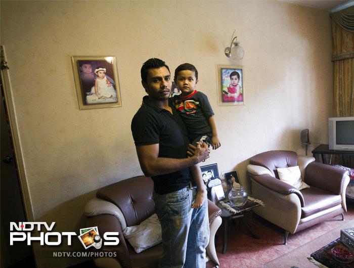 Pakistani cricketer Danish Kaneria poses with his son in his house in Karachi. (July, 2011).