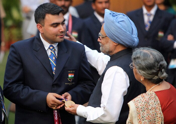 Prime Minister Manmohan Singh and his wife Gursharan Kaur congratulate India's ace shooter Gagan Narang, who won four gold medals in the XIX Commonwealth Games in New Delhi. (PTI Photo)