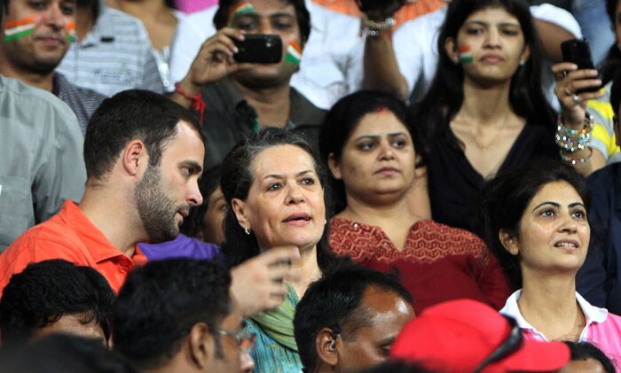 Congress Party President Sonia Gandhi (C) and her son Rahul Gandhi /L) speak as they sit in the stands  during the field hockey match between India and Pakistan for the XIX Commonwealth Games at The Major Dhyan Chand National Stadium in New Delhi. India defeated Pakistan 7-4 in a Commonwealth Games men's Pool A hockey match to move into the semi-finals. (AFP Photo)