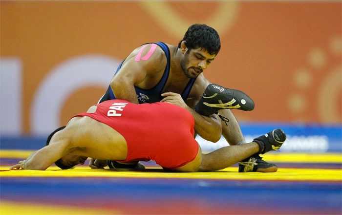 India's Sushil Kumar wrestles with Pakistan's Muhammad Salman in their 66kg men's free style wrestling quarterfinals bout during the Commonwealth Games at the Indira Gandhi Sports Complex in New Delhi. (AP Photo)