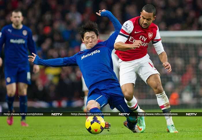 Nicklas Bendtner and Theo Walcott scored last-gasp goals as Arsenal edged Cardiff City 2-0 on New Year's Day to preserve their place at the Premier League summit. Manchester City win, Arsenal maintain place at top of the table