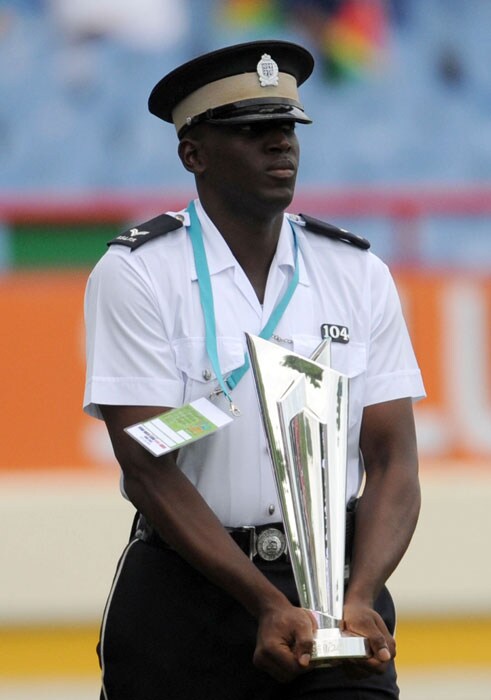 A policeman walks past the winners trophy of the ICC World Twenty20 World cup kept on display during the Twenty20 first semifinal match between Sri Lanka and England at the Beausejour Cricket Ground. (AFP Photo) WT20: Eng vs SL