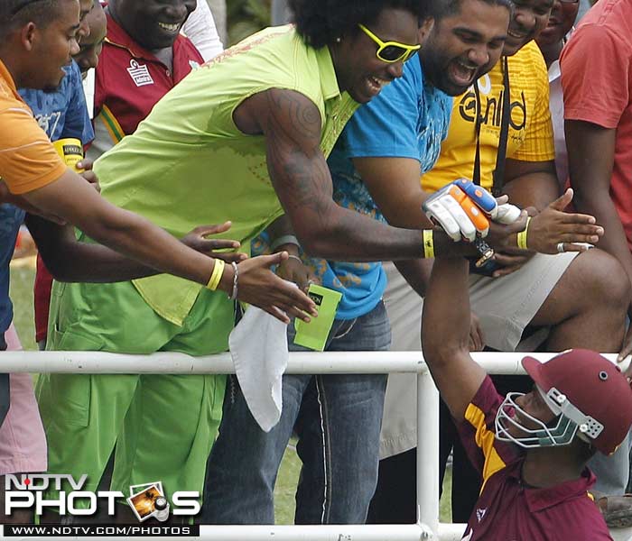 West Indies' Marlon Samuels, below, celebrates with Chris Gayle. New look Gayle graces the stands