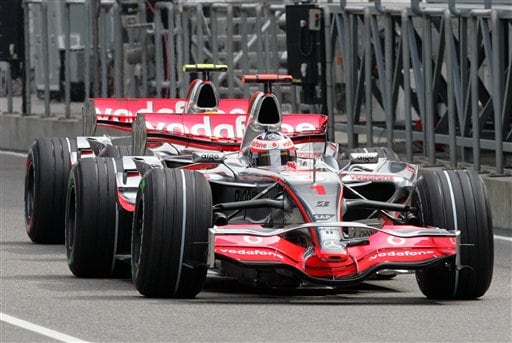 McLaren-Mercedes' Spanish Fernando Alonso, front, and rival British Lewis Hamilton drive back to the team's garage during the practice session. Hamilton awaits verdict